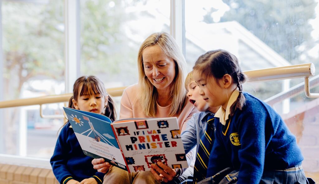 Junior students reading with teacher
