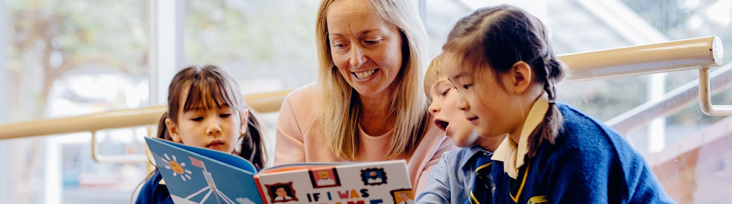 Junior students reading with teacher