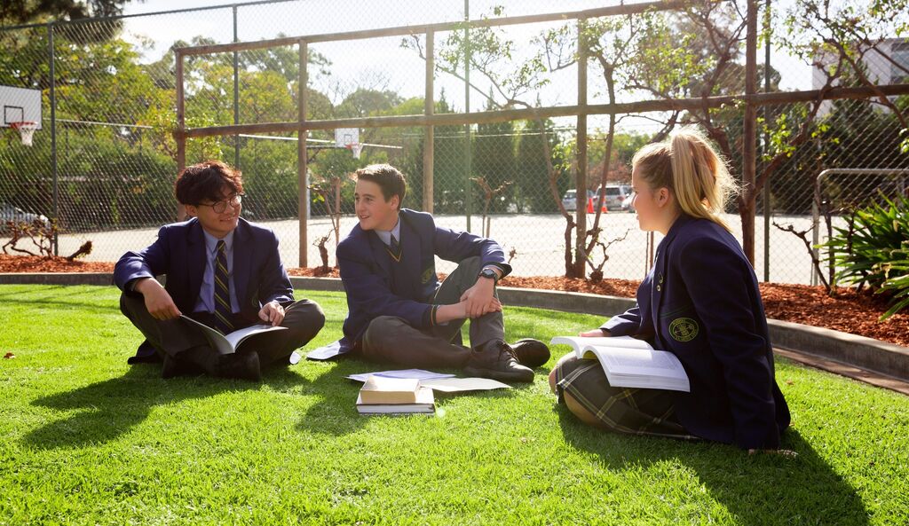 Boarding students sitting outside studying
