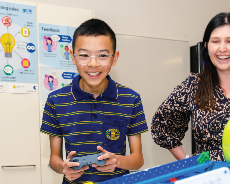 Teacher with student in robotics class