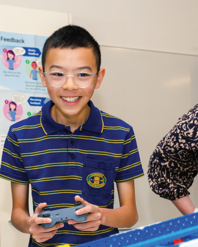 Teacher with student in robotics class