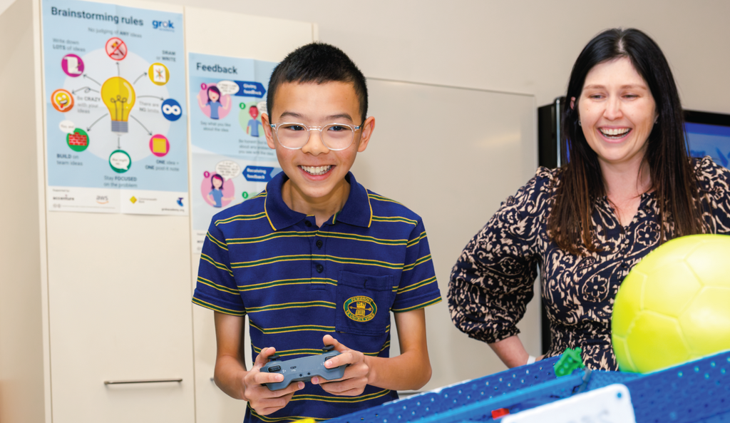 Teacher with student in robotics class